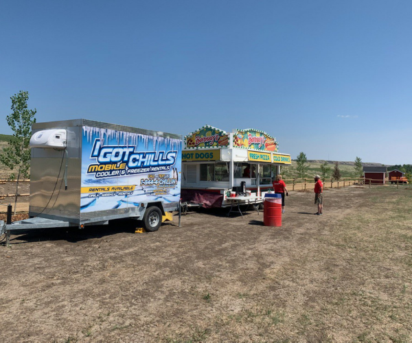 Mobile freezer trailer supporting a food concession at an outdoor Alberta event