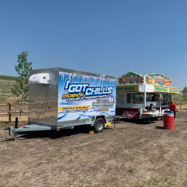Mobile freezer trailer beside a concession trailer at an outdoor event